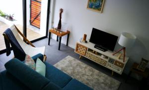 a living room with a blue couch and a tv at Furnas Springs in Furnas