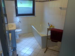 a bathroom with a tub and a toilet and a sink at FeWo Gelnhausen in Gründau +2 photos