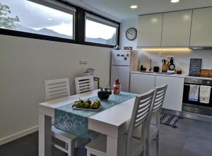 a kitchen with a table with a bowl of fruit on it at Furnas Springs in Furnas