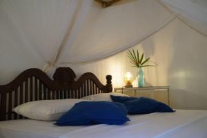 un letto con due cuscini blu sopra di FIVE a Tangalle