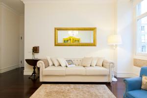 ein Wohnzimmer mit einem weißen Sofa und einem Spiegel in der Unterkunft JOIVY Baixa Deluxe Apartments in Lissabon