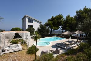 een zwembad met ligstoelen en een huis bij Entechnos Living in Skiathos-stad