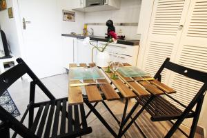a dining room table with two chairs in a kitchen at STUDIO COSY LE Ti PARIS WIFI & NETFLIX in Deuil-la-Barre
