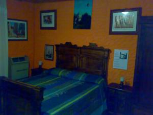 - une chambre avec un lit et des photos sur le mur dans l'établissement IANUA COELI 3, à Mosso Santa Maria