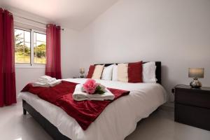 a bedroom with a large bed with red curtains at Casa Santana in Estreito da Calheta