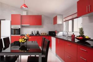 a kitchen with red cabinets and a table with fruit on it at Casa Santana in Estreito da Calheta