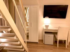 uma escada num quarto com uma secretária e uma televisão em Borgo Empedocle House em Catânia