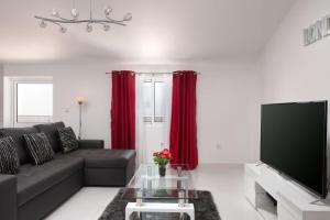 a living room with a couch and red curtains at Casa Santana in Estreito da Calheta