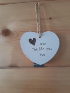 a white heart ornament with the words love the life you live at La vieille école in Montjovet