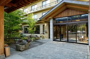 a building with large glass doors and a patio at Shibu Hotel in Yamanouchi