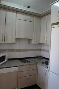 セビリアにあるAlfalfa Homeのキッチン(白いキャビネット、白い冷蔵庫付)