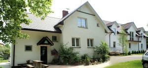 a large white house with a bench in front of it at NSSM Tanie Spanie in Święta Katarzyna