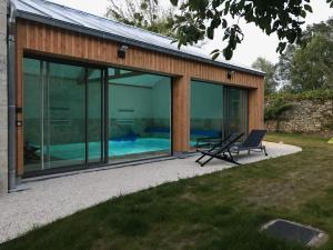 uma casa de vidro com piscina no quintal em Gite L'Hermine em Azay-le-Rideau
