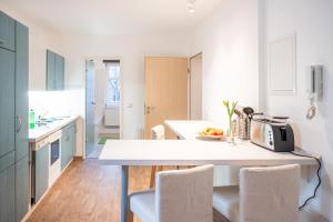 德勒斯登的住宿－Helle Ferienwohnung im Hinterhof，白色的厨房配有桌椅