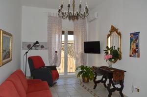 uma sala de estar com um sofá vermelho e uma televisão em Antica Dimora in Centro em Salerno
