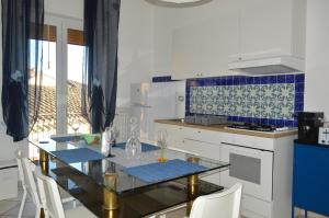 - une cuisine avec une table, des chaises et une cuisinière dans l'établissement Antica Dimora in Centro, à Salerne