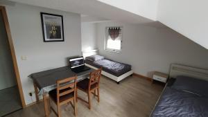 a room with a desk and a bed and a table with a laptop at Wohnung Neunkirchen 3 in Neunkirchen am Brand