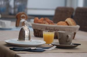 a table with a plate of food and a cup of orange juice at B&B Roodbeekerhof in Vlodrop