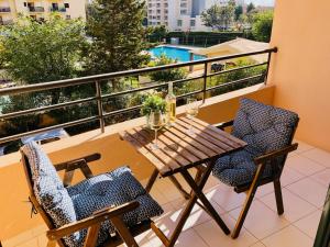 balcone con tavolo in legno e 2 sedie di Paradise Luxury Apartment - Praia da Rocha a Portimão