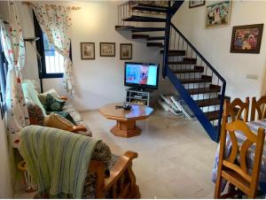 uma sala de estar com um sofá e uma televisão e escadas em Vivienda Agaete Paradise em Puerto de las Nieves