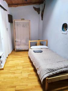 Łóżko w pokoju z drewnianą podłogą w obiekcie Casa Farfarnicola w mieście Aguafría
