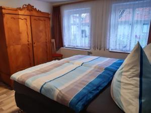 a bedroom with a large bed and two windows at Ferienhaus Paries in Nitzow