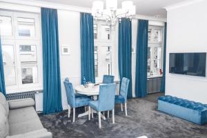 une salle à manger avec une table et des chaises bleues dans l'établissement Apartamenty Hexus - Ofiar Oświęcimskich - Wrocław centrum Rynek, à Wrocław