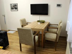 a dining room table with chairs and a television on the wall at Ferienwohnung Nimritz in Oppurg