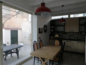レッチェにあるCasa Lauretta - terrazza - garage wifi e bici gratuiteのキッチン、ダイニングルーム(木製のテーブルと椅子付)