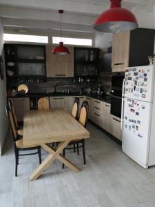 レッチェにあるCasa Lauretta - terrazza - garage wifi e bici gratuiteのキッチン(木製テーブル、白い冷蔵庫付)