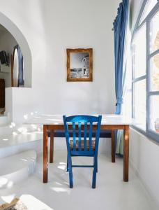 9 Muses Exclusive Apartments في Grikos: كرسي ازرق جالس على طاولة في الغرفة