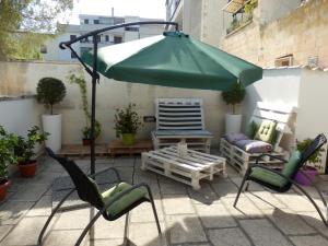 レッチェにあるCasa Lauretta - terrazza - garage wifi e bici gratuiteの緑のパラソル(椅子、ソファ付)