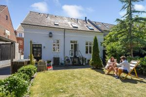 two women sitting on chairs in the yard of a house at Sweethome Guesthouse in Esbjerg