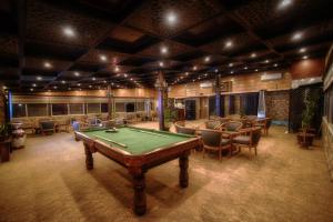 a billiard room with a pool table and chairs at La Maison Hotel in Wadi Musa
