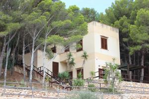 a house on the side of a hill with trees at La Pineta in Favignana