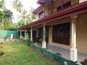 ein Haus mit Rasen davor in der Unterkunft Ceylon Epic Villa in Bentota