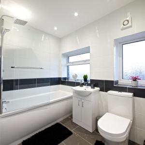 a bathroom with a toilet and a tub and a sink at Beautiful Cozy Home With Free Parking in Manchester +19 photos