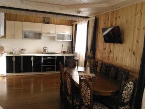 a kitchen with a wooden table and a dining room at Сімейний котедж КРАЄВИД чан джакузі сауна in Mykulychyn