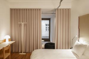 a room with a bed, chair and a window at Haus im Tal in Munich
