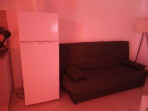 a pink room with a couch and a refrigerator at Casa Altavista in Vilaflor