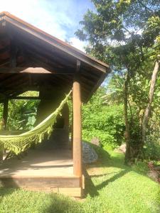 a pavilion with a hammock in the grass at CHALÉS MAGIA DA MONTANHA 2 in Visconde De Maua