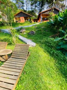 a wooden walkway in the grass in front of a house at CHALÉS MAGIA DA MONTANHA 2 in Visconde De Maua