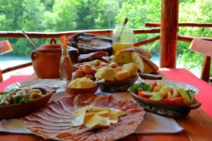 a table topped with different types of food on a table at Rafting Center Drina Tara in Bastasi