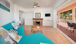 Una sala de estar con un sofá azul y una chimenea. en SAND - EnjoytheSeainColonia WE RENT FROM SAT TO SAT, EXCEPT WINTER, en Colonia de Sant Jordi