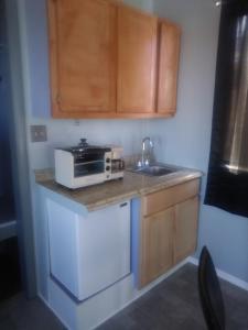 una cucina con lavello e forno a microonde su un bancone di Mountain view efficiency a Tombstone