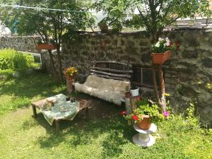 a garden with a couch and a table and flowers at Rocky Island in Kazbegi