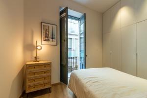 a bedroom with a bed and a dresser and a window at Balmis Plaza Apartments in Alicante