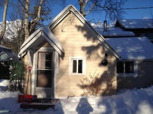 a small house with snow on the roof at Holiday Lodge Cabins in Banff