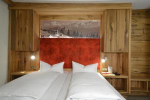 ライト・イム・ヴィンクルにあるHotel Edelweiß Garniの白いベッド2台が備わるベッドルーム1室、壁に絵画が飾られています。