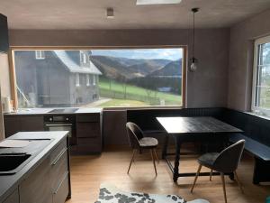 a kitchen with a large window and a table and chairs at Bergchalet Hinterstoder in Hinterstoder